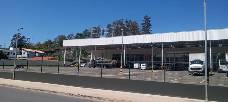 Vista diurna da fachada e estacionamento do Mart Minas em Caeté